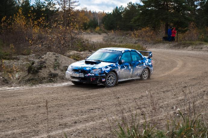 blue sedan passing by a rough road